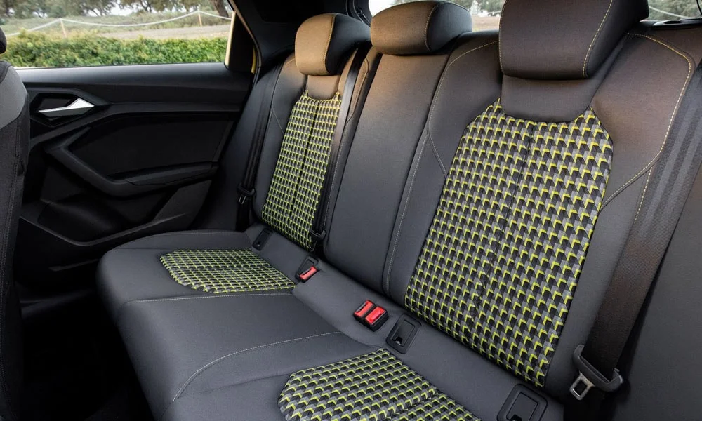 Фото Audi A1 Sportback — задние сиденья. Посадка второго ряда: подголовники и подлокотник. Спинки складываются под длинные грузы у большинства версий Audi A1 Sportback — задние сиденья