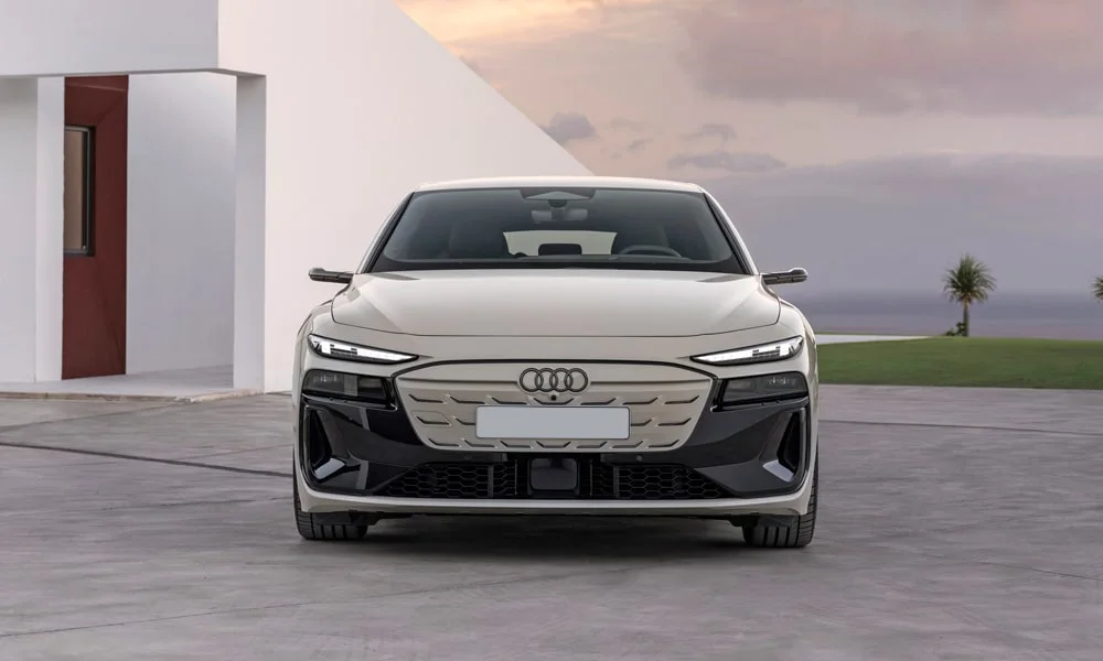 Фото Audi A6 Sportback e-tron (2024) — вид спереди, фото 5. Передок в бежевом исполнении — крупная светотехника и выразительный бампер Audi A6 Sportback e-tron (2024) — вид спереди, фото 5