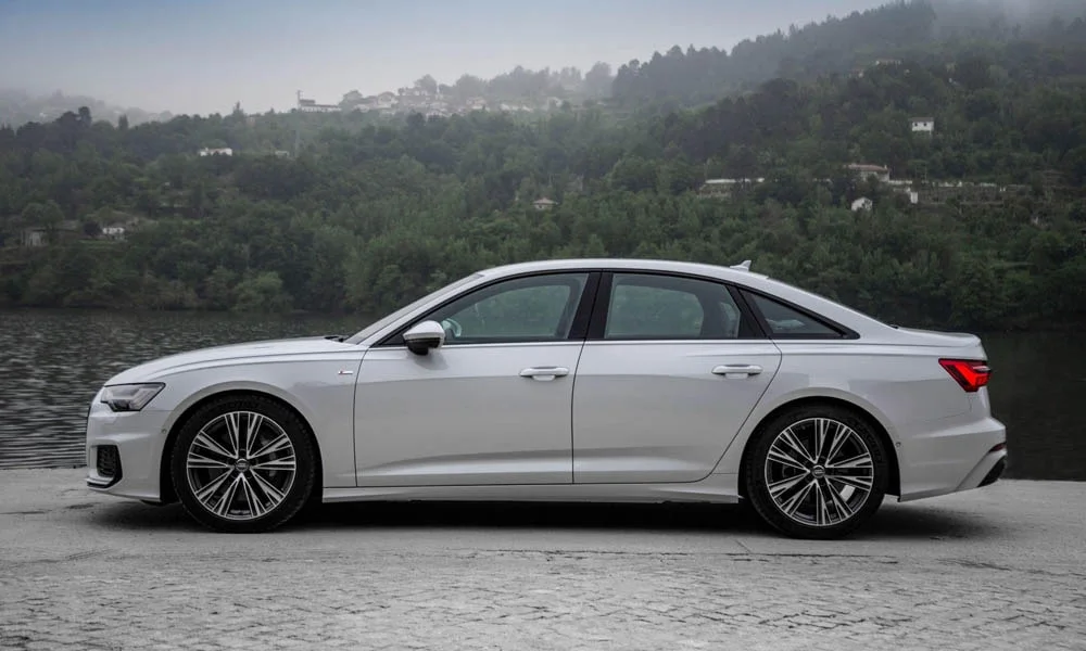 Фото Audi A6 — вид сбоку. Профиль в белом цвете: соотношение колёсной базы и свесов. Длинная база — простор второго ряда; короткие свесы упрощают парковку Audi A6 — вид сбоку
