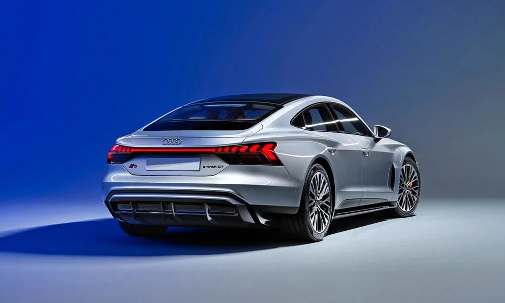 Фото Audi e-tron GT (2024) — вид сзади, фото 3. Корма в серебристом цвете: графика фонарей и пластика пятой двери. Светодиодная полоса или раздельные секции — задняя оптика стала главным украшением кормы Audi e-tron GT (2024) — вид сзади, фото 3
