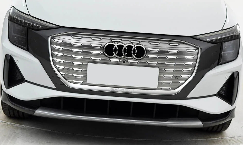Фото Audi Q5 e-tron (2024) — решётка радиатора. Фирменный рисунок облицовки — визитная карточка марки. За решёткой у многих комплектаций стоит радар адаптивного круиз-контроля Audi Q5 e-tron (2024) — решётка радиатора