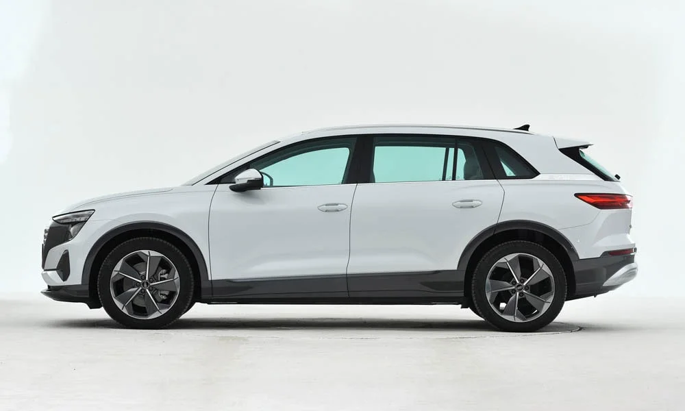 Фото Audi Q5 e-tron (2024) — вид сбоку, фото 2. Сбоку читаются линия остекления и характер выштамповок на белом кузове Audi Q5 e-tron (2024) — вид сбоку, фото 2