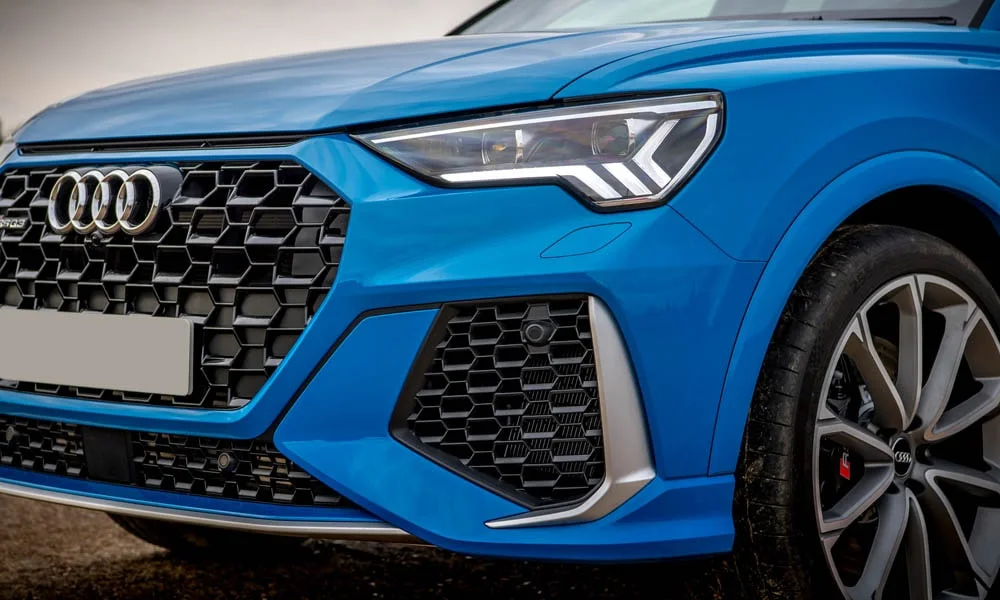 Фото Audi RS Q3 Sportback (2024) — вид спереди, фото 5. Передок в синем исполнении — крупная светотехника и выразительный бампер Audi RS Q3 Sportback (2024) — вид спереди, фото 5