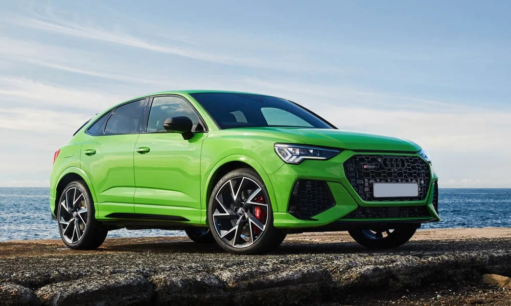Фото Audi RS Q3 Sportback (2024) — вид спереди, фото 7. Зелёный кузов, строгая симметрия оптики — базовый ракурс знакомства с дизайном. Рисунок ходовых огней — подпись модели, по нему её узнают в потоке Audi RS Q3 Sportback (2024) — вид спереди, фото 7