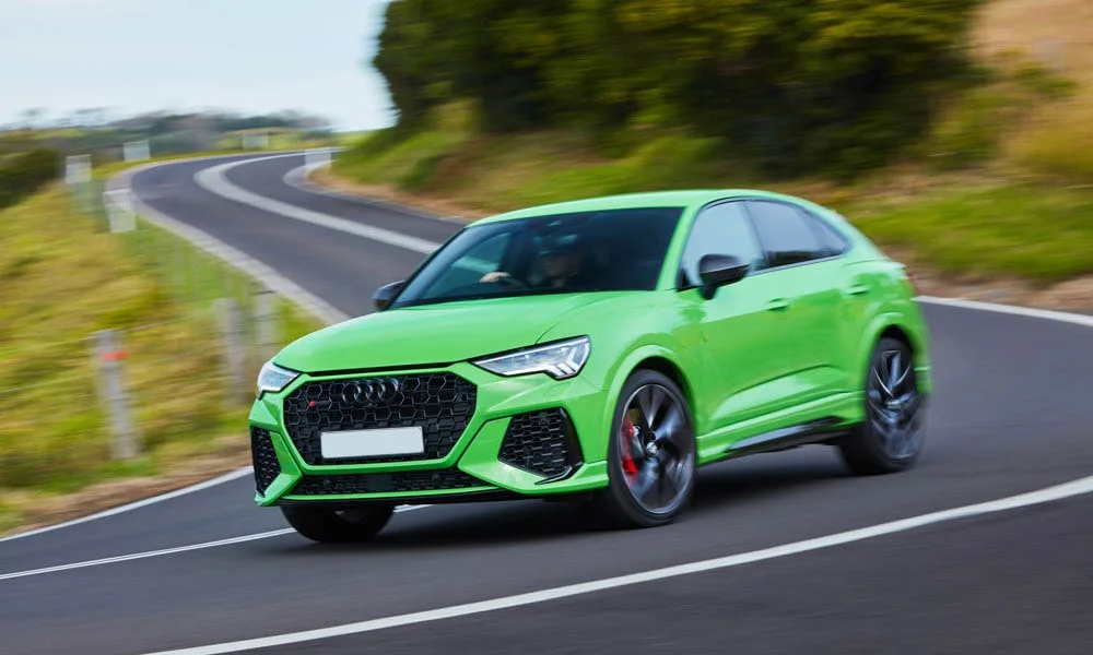 Фото Audi RS Q3 Sportback (2024) — вид спереди, фото 8. Кузов в зелёном цвете: рисунок оптики и решётки задаёт узнаваемое «лицо» модели Audi RS Q3 Sportback (2024) — вид спереди, фото 8
