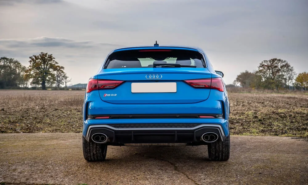 Фото Audi RS Q3 Sportback (2024) — вид сзади, фото 3. Корма в синем цвете: графика фонарей и пластика пятой двери. Насадки выхлопа или их имитация внизу бампера различают версии Audi RS Q3 Sportback (2024) — вид сзади, фото 3