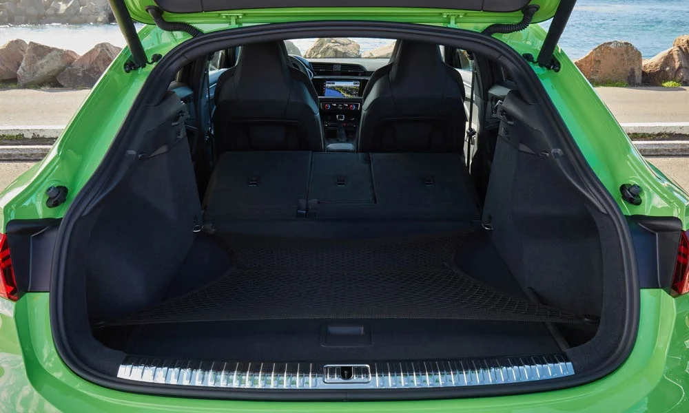 Фото Audi RS Q3 Sportback (2024) — багажник. Форма проёма, ровный пол и организация пространства. Под полом обычно размещены органайзер, докатка или ремкомплект Audi RS Q3 Sportback (2024) — багажник