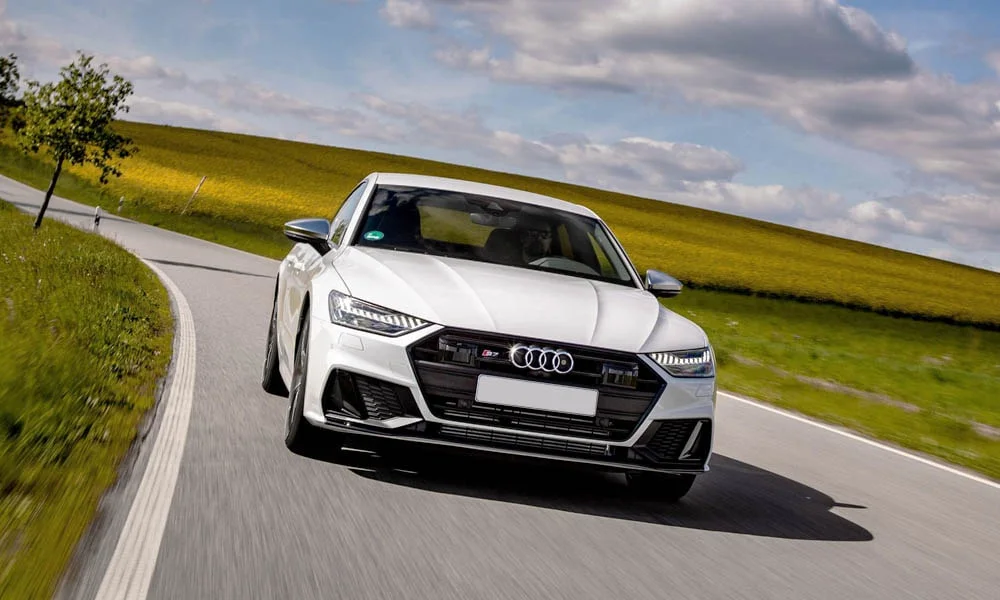 Фото Audi S7 Sportback — вид спереди, фото 4. Анфас: пропорции капота, посадка кузова и графика ходовых огней. Дневные ходовые огни включаются автоматически с запуском Audi S7 Sportback — вид спереди, фото 4