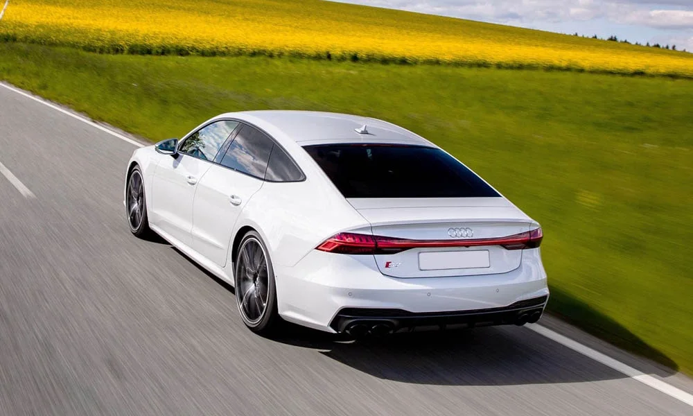 Фото Audi S7 Sportback — вид сзади, фото 3. Корма в белом цвете: графика фонарей и пластика пятой двери. Насадки выхлопа или их имитация внизу бампера различают версии Audi S7 Sportback — вид сзади, фото 3