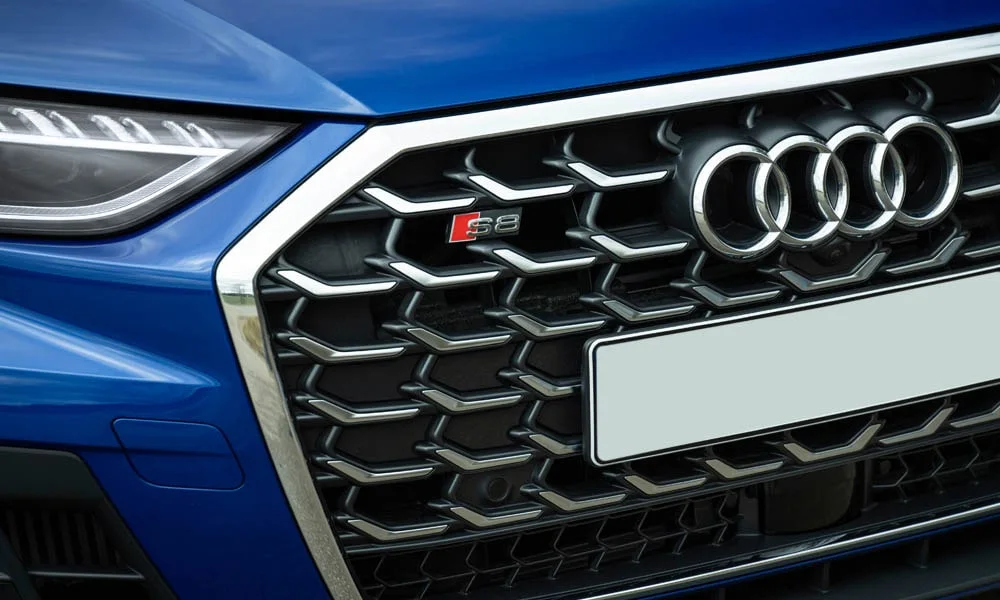Фото Audi S8 (2024) — решётка радиатора. Рисунок решётки: сетка, ламели или глухая панель у электроверсий. Активные жалюзи за решёткой закрываются на трассе ради аэродинамики — есть у ряда моделей Audi S8 (2024) — решётка радиатора