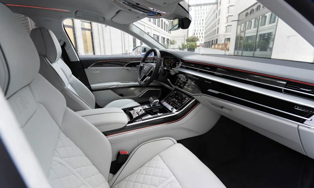 Фото Audi S8 (2024) — интерьер. Салон в светло-серой отделке: архитектура передней панели, консоль и кресла Audi S8 (2024) — интерьер