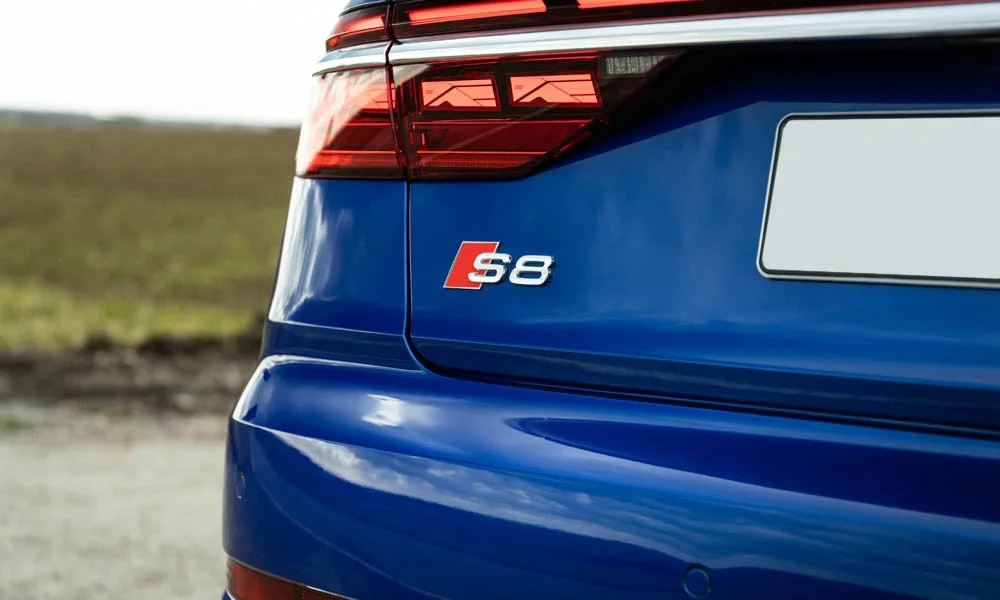Фото Audi S8 (2024) — вид сзади, фото 5. Синий кузов сзади — фонари и бампер определяют ночной образ модели. Насадки выхлопа или их имитация внизу бампера различают версии Audi S8 (2024) — вид сзади, фото 5
