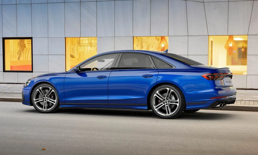 Фото Audi S8 (2024) — вид сзади, фото 10. Линия крыши, стойки и задняя дверь в синем исполнении. Насадки выхлопа или их имитация внизу бампера различают версии Audi S8 (2024) — вид сзади, фото 10