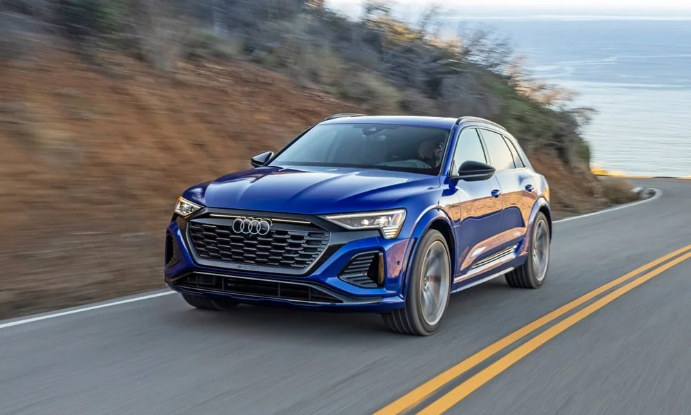 Фото Audi SQ8 e-tron — вид спереди, фото 8. Передок в синем исполнении — крупная светотехника и выразительный бампер. Дневные ходовые огни включаются автоматически с запуском Audi SQ8 e-tron — вид спереди, фото 8