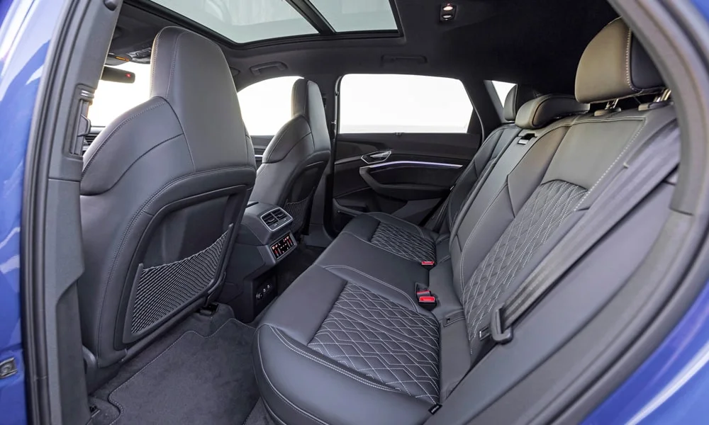 Фото Audi SQ8 e-tron — задние сиденья. Посадка второго ряда: подголовники и подлокотник. Спинки складываются под длинные грузы у большинства версий Audi SQ8 e-tron — задние сиденья