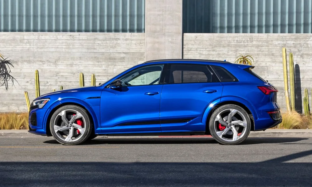 Фото Audi SQ8 e-tron — вид сбоку, фото 4. Синий кузов в профиль — пропорции, высота посадки и дизайн дисков. Хромированные или чёрные молдинги окон отличают комплектации Audi SQ8 e-tron — вид сбоку, фото 4