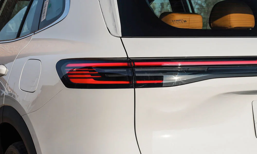 Фото Belgee X80 PHEV — вид сзади, фото 4. Корма в белом цвете: графика фонарей и пластика пятой двери. Насадки выхлопа или их имитация внизу бампера различают версии Belgee X80 PHEV — вид сзади, фото 4