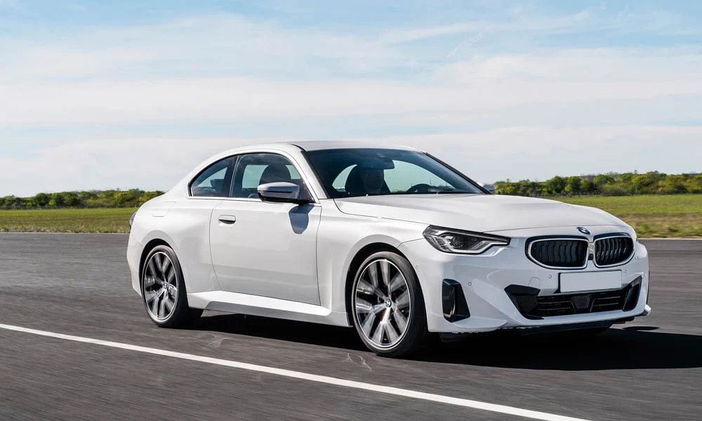 Фото BMW 2 серии — вид спереди, фото 5. Белый кузов, строгая симметрия оптики — базовый ракурс знакомства с дизайном. Рисунок ходовых огней — подпись модели, по нему её узнают в потоке BMW 2 серии — вид спереди, фото 5