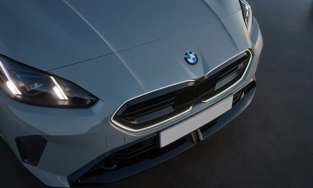 Фото BMW 2 серии Gran Coupe (2024) — вид спереди, фото 3. Серый кузов, строгая симметрия оптики — базовый ракурс знакомства с дизайном. Рисунок ходовых огней — подпись модели, по нему её узнают в потоке BMW 2 серии Gran Coupe (2024) — вид спереди, фото 3