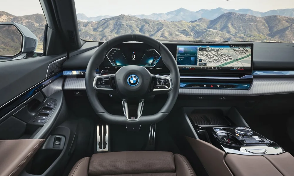Фото BMW 5 серии (2024) — интерьер. Общий план салона: архитектура панели, консоль и кресла. Уровень отделки читается по стыкам панелей и мягким поверхностям в зонах касания BMW 5 серии (2024) — интерьер