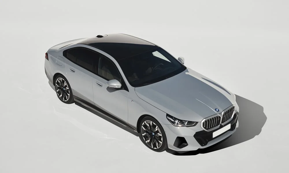 Фото BMW 5 серии (2024) — крыша. Линия крыши и панорамное остекление с высоты. Панорамное стекло зрительно увеличивает салон; шторка спасает в жару BMW 5 серии (2024) — крыша