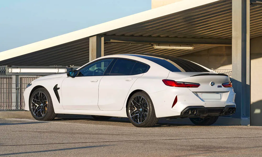 Фото BMW M8 Gran Coupe (2022) — вид сзади, фото 8. Линия крыши, стойки и задняя дверь в белом исполнении. Насадки выхлопа или их имитация внизу бампера различают версии BMW M8 Gran Coupe (2022) — вид сзади, фото 8