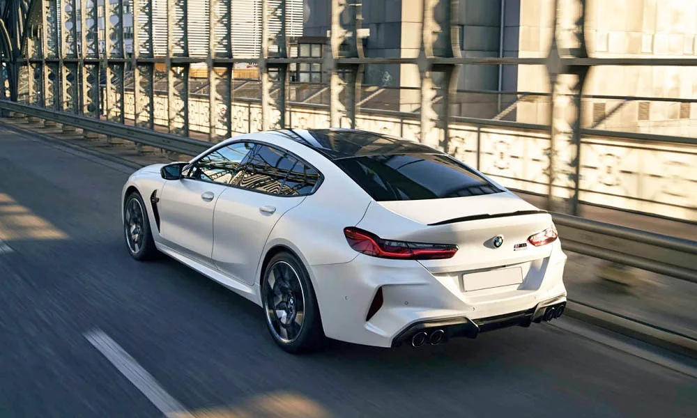 Фото BMW M8 Gran Coupe (2022) — вид сзади, фото 9. Белый кузов сзади — фонари и бампер определяют ночной образ модели BMW M8 Gran Coupe (2022) — вид сзади, фото 9