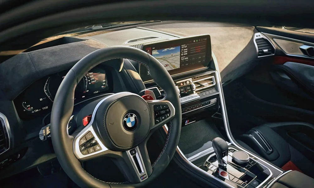 Фото BMW M8 Gran Coupe (2022) — руль. Обшивка обода и компоновка спиц крупным планом. Клавиши на спицах управляют медиа, круизом и ассистентами — руки остаются на руле BMW M8 Gran Coupe (2022) — руль