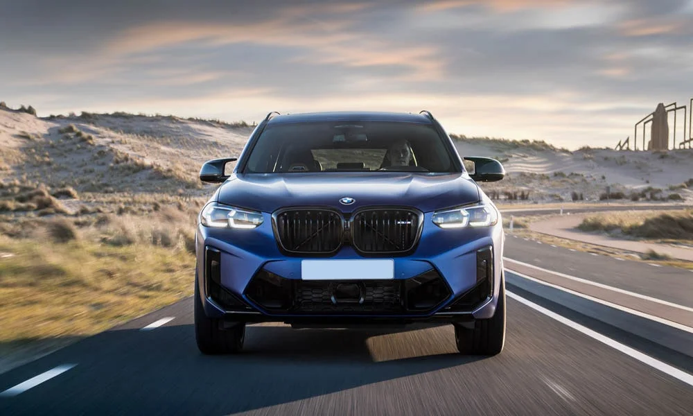 Фото BMW X3 M (2024) — вид спереди, фото 10. Анфас: пропорции капота, посадка кузова и графика ходовых огней. Дневные ходовые огни включаются автоматически с запуском BMW X3 M (2024) — вид спереди, фото 10