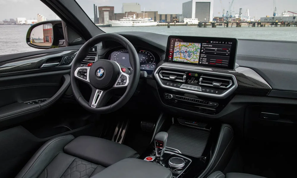 Фото BMW X4 M (2024) — интерьер. Общий план салона: архитектура панели, консоль и кресла. Уровень отделки читается по стыкам панелей и мягким поверхностям в зонах касания BMW X4 M (2024) — интерьер