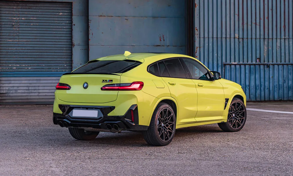 Фото BMW X4 M (2024) — вид сзади, фото 4. Жёлтый кузов сзади — фонари и бампер определяют ночной образ модели. Насадки выхлопа или их имитация внизу бампера различают версии BMW X4 M (2024) — вид сзади, фото 4