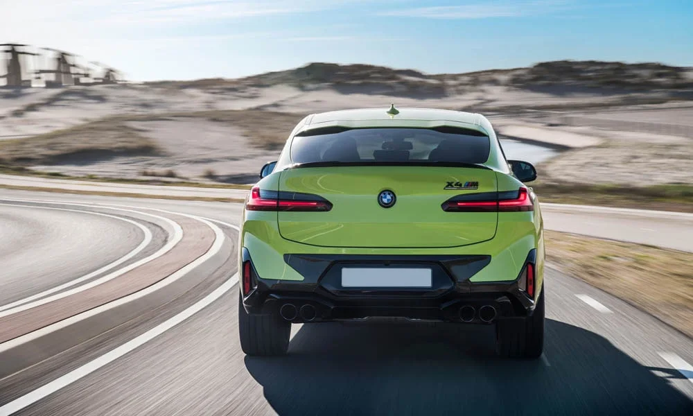 Фото BMW X4 M (2024) — вид сзади, фото 6. Корма в зелёном цвете: графика фонарей и пластика пятой двери. Светодиодная полоса или раздельные секции — задняя оптика стала главным украшением кормы BMW X4 M (2024) — вид сзади, фото 6