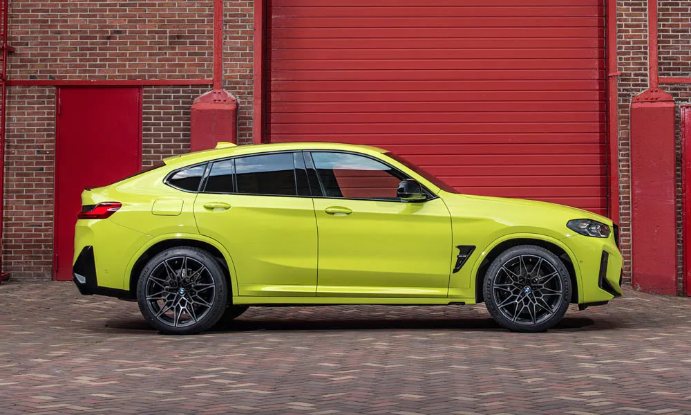 Фото BMW X4 M (2024) — вид сбоку, фото 5. Жёлтый кузов в профиль — пропорции, высота посадки и дизайн дисков BMW X4 M (2024) — вид сбоку, фото 5
