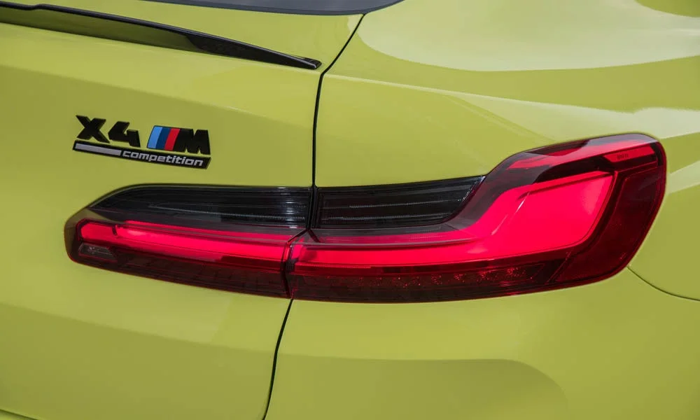 Фото BMW X4 M (2024) — задние фонари. Графика секций крупным планом — ночная подпись модели BMW X4 M (2024) — задние фонари