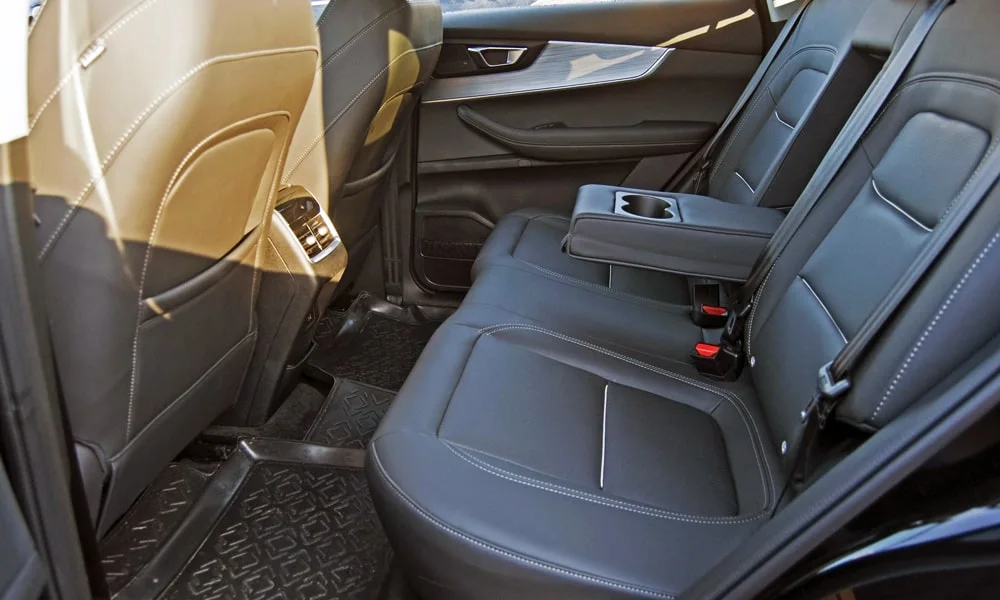 Фото Chery Tiggo 7 Pro Plug-in Hybrid (2023) — задние сиденья, фото 4. Посадка второго ряда: подголовники и подлокотник. Плоский пол упрощает посадку втроём Chery Tiggo 7 Pro Plug-in Hybrid (2023) — задние сиденья, фото 4