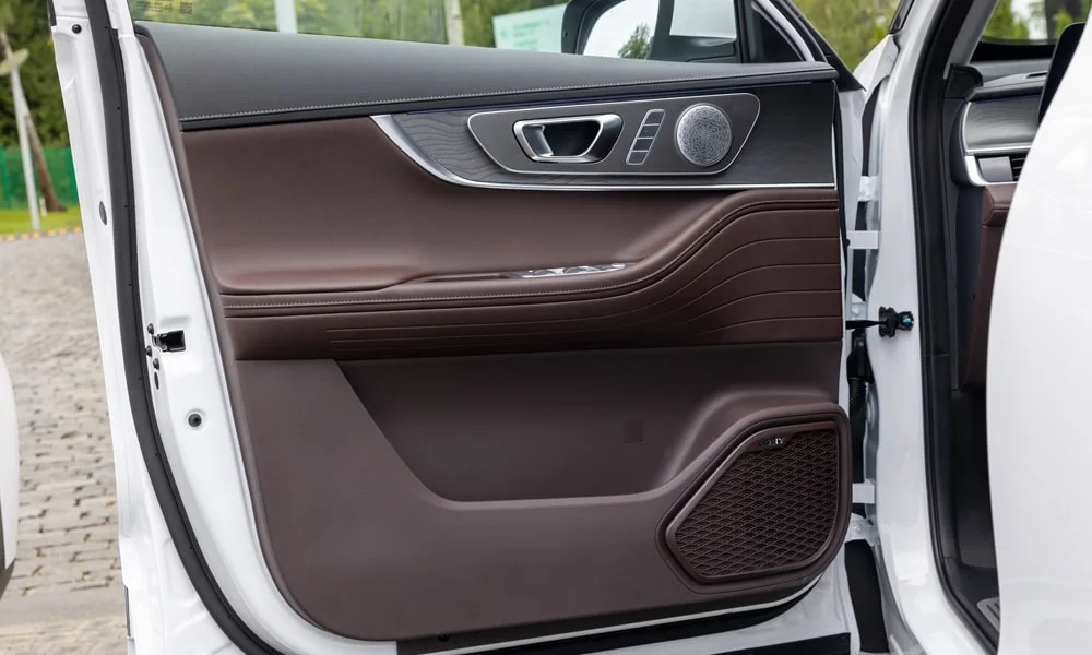 Фото Chery Tiggo 8 Pro Max (2022) — дверная карта, фото 2. Внутренняя панель двери: сочетание материалов и компоновка управления в коричневой гамме. Мягкая вставка в зоне локтя — то, что чувствуешь каждый день Chery Tiggo 8 Pro Max (2022) — дверная карта, фото 2