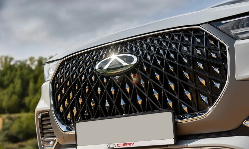Фото Chery Tiggo 8 Pro Max (2022) — решётка радиатора. Фирменный рисунок облицовки — визитная карточка марки Chery Tiggo 8 Pro Max (2022) — решётка радиатора