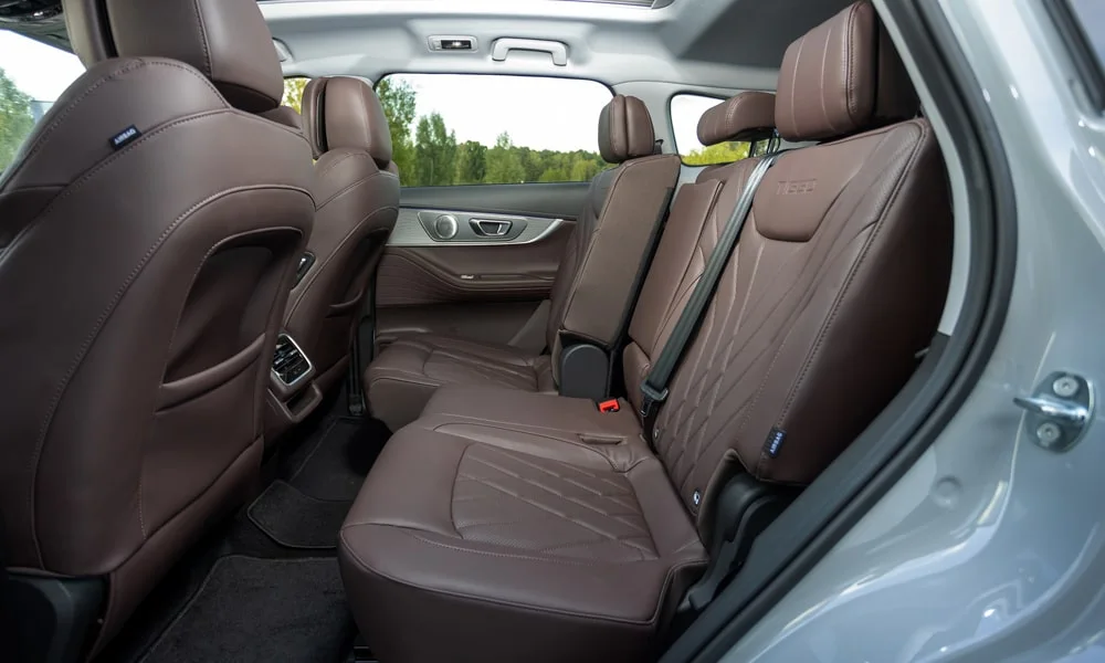 Фото Chery Tiggo 8 Pro Max (2022) — задние сиденья, фото 2. Посадка второго ряда: подголовники и подлокотник. Крепления ISOFIX для детских кресел — в основании спинки Chery Tiggo 8 Pro Max (2022) — задние сиденья, фото 2