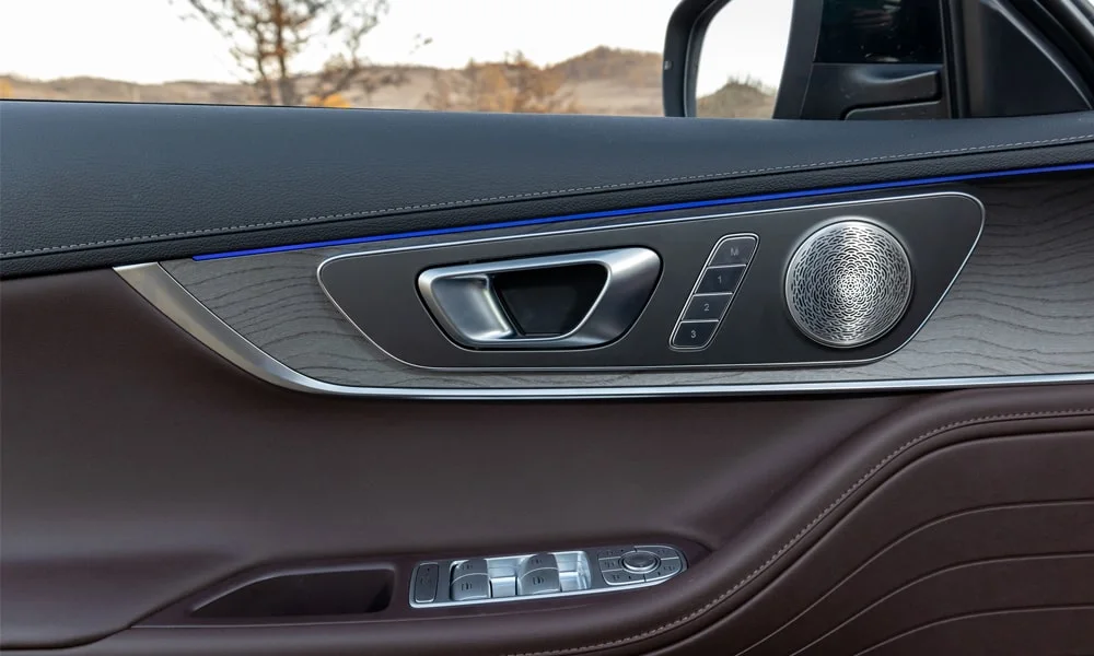 Фото Chery Tiggo 8 Pro Plug-in Hybrid (2023) — дверная карта. Дверная карта в коричневой отделке: подлокотник, динамик и блок стеклоподъёмников Chery Tiggo 8 Pro Plug-in Hybrid (2023) — дверная карта