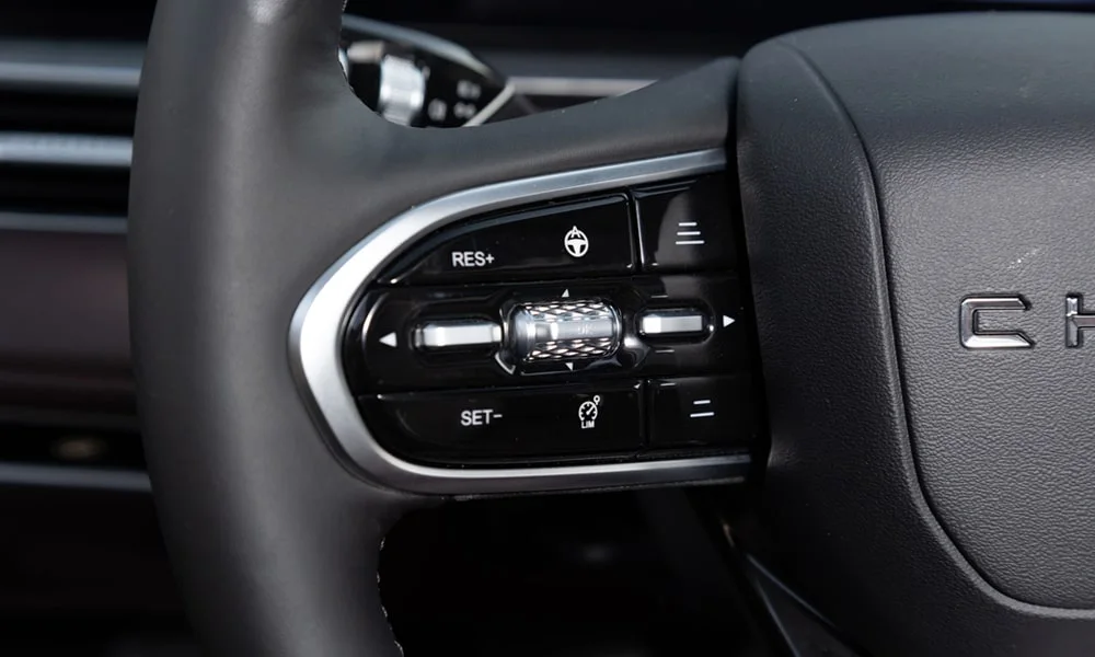 Фото Chery Tiggo 8 Pro Plug-in Hybrid (2023) — руль. Обшивка обода и компоновка спиц крупным планом. Правильная посадка: руки на «9 и 3», приборы читаются поверх обода Chery Tiggo 8 Pro Plug-in Hybrid (2023) — руль