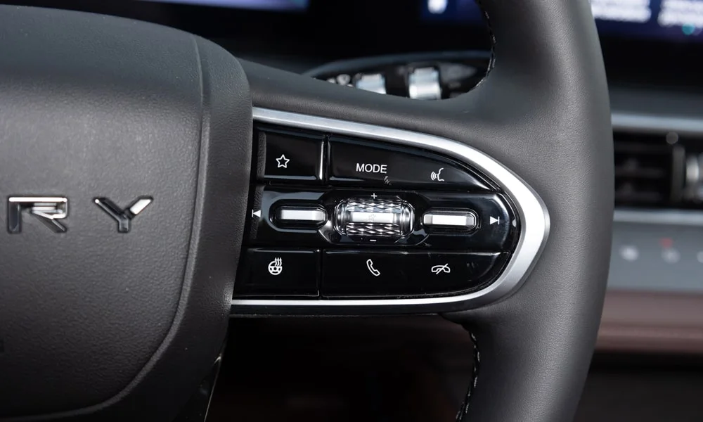 Фото Chery Tiggo 8 Pro Plug-in Hybrid (2023) — руль, фото 2. Обшивка обода и компоновка спиц крупным планом. Правильная посадка: руки на «9 и 3», приборы читаются поверх обода Chery Tiggo 8 Pro Plug-in Hybrid (2023) — руль, фото 2