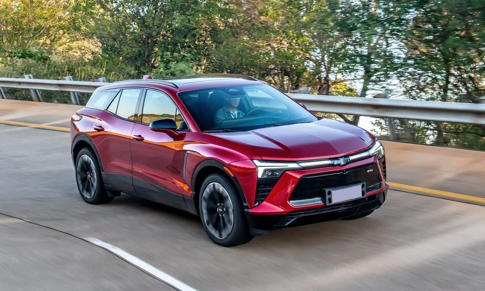 Фото Chevrolet Blazer (2024) — вид спереди, фото 6. Кузов в красном цвете: рисунок оптики и решётки задаёт узнаваемое «лицо» модели. Рисунок ходовых огней — подпись модели, по нему её узнают в потоке Chevrolet Blazer (2024) — вид спереди, фото 6