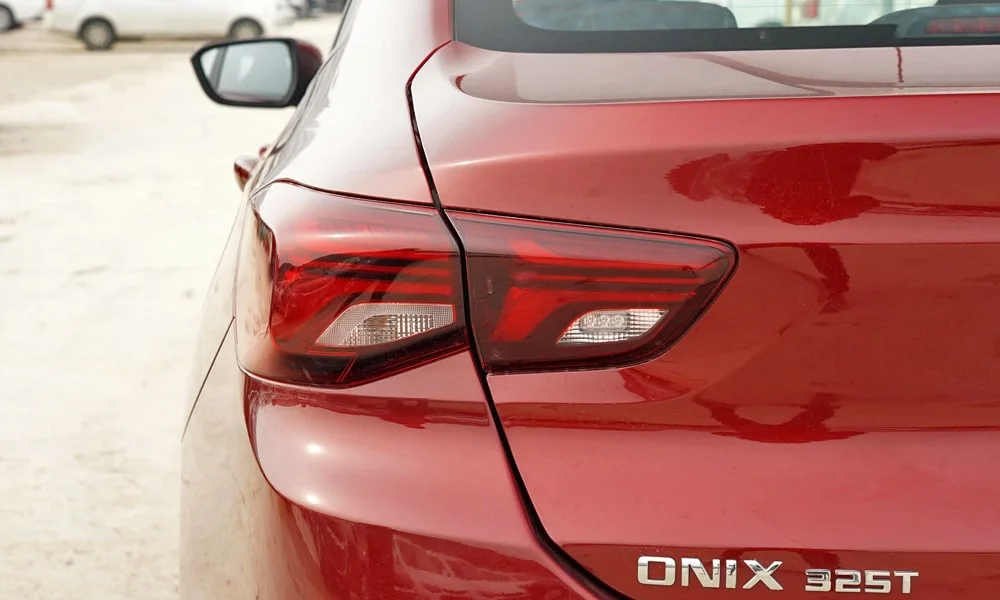Фото Chevrolet Onix (2024) — вид сзади, фото 4. Графика фонарей, бампер и оформление пятой двери. Насадки выхлопа или их имитация внизу бампера различают версии Chevrolet Onix (2024) — вид сзади, фото 4