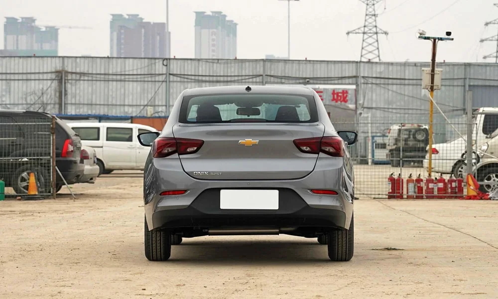 Фото Chevrolet Onix (2024) — вид сзади, фото 5. Линия крыши, стойки и задняя дверь в сером исполнении. Насадки выхлопа или их имитация внизу бампера различают версии Chevrolet Onix (2024) — вид сзади, фото 5