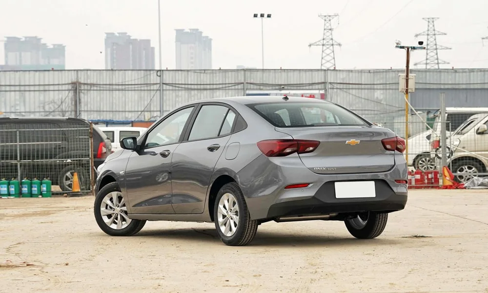 Фото Chevrolet Onix (2024) — вид сзади, фото 6. Серый кузов сзади — фонари и бампер определяют ночной образ модели Chevrolet Onix (2024) — вид сзади, фото 6