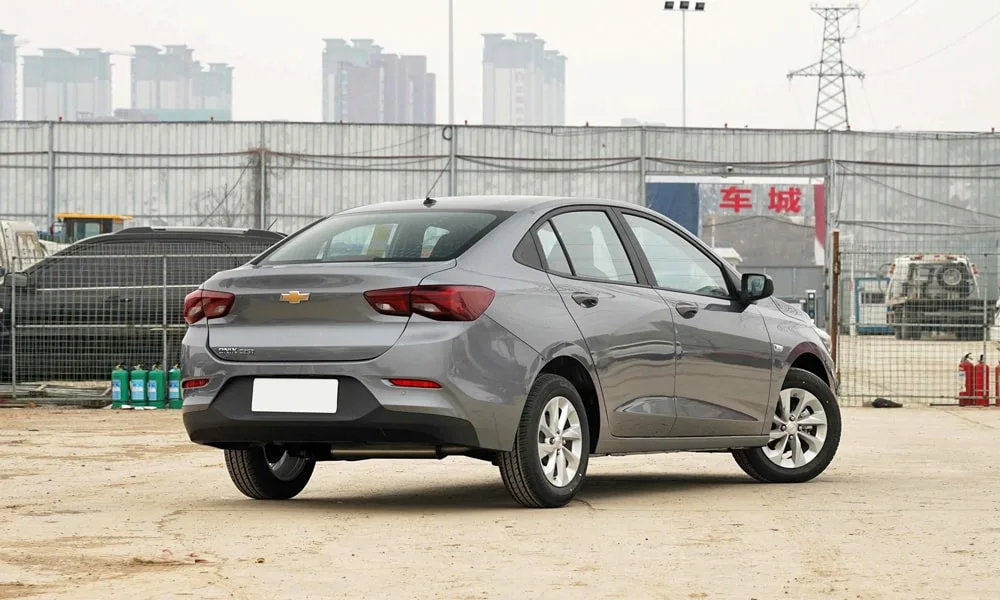 Фото Chevrolet Onix (2024) — вид сзади, фото 7. Серый кузов сзади — фонари и бампер определяют ночной образ модели Chevrolet Onix (2024) — вид сзади, фото 7