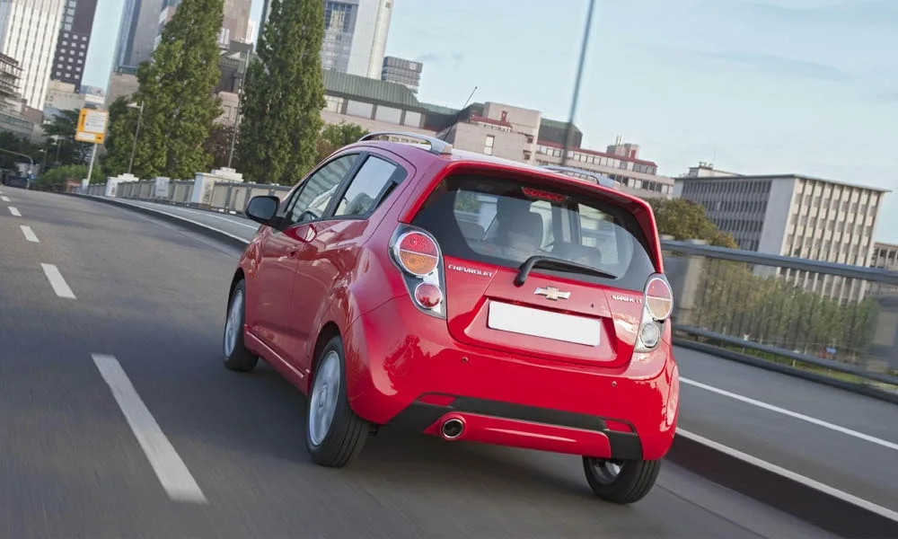 Фото Chevrolet Spark — вид сзади, фото 7. Корма в красном цвете: графика фонарей и пластика пятой двери. Насадки выхлопа или их имитация внизу бампера различают версии Chevrolet Spark — вид сзади, фото 7