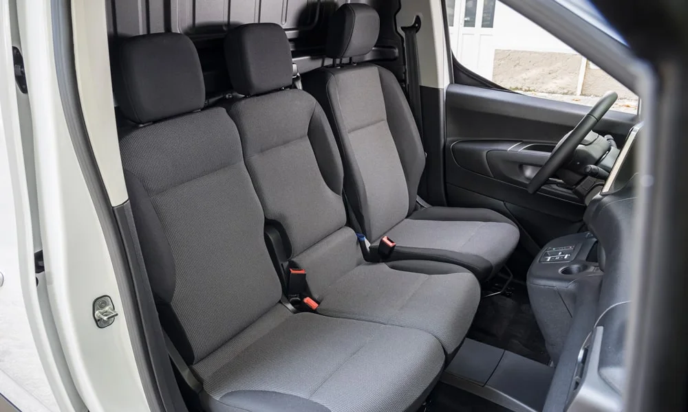 Фото Citroen Berlingo (2024) — задние сиденья. Задний диван в практичной ткани: посадка и центральный подлокотник. Спинки складываются под длинные грузы у большинства версий Citroen Berlingo (2024) — задние сиденья