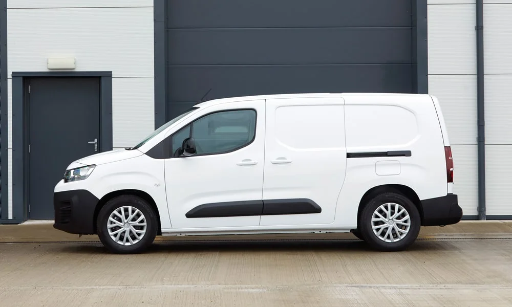 Фото Citroen Berlingo (2024) — вид сбоку, фото 4. Профиль в белом цвете: соотношение колёсной базы и свесов. Длинная база — простор второго ряда; короткие свесы упрощают парковку Citroen Berlingo (2024) — вид сбоку, фото 4
