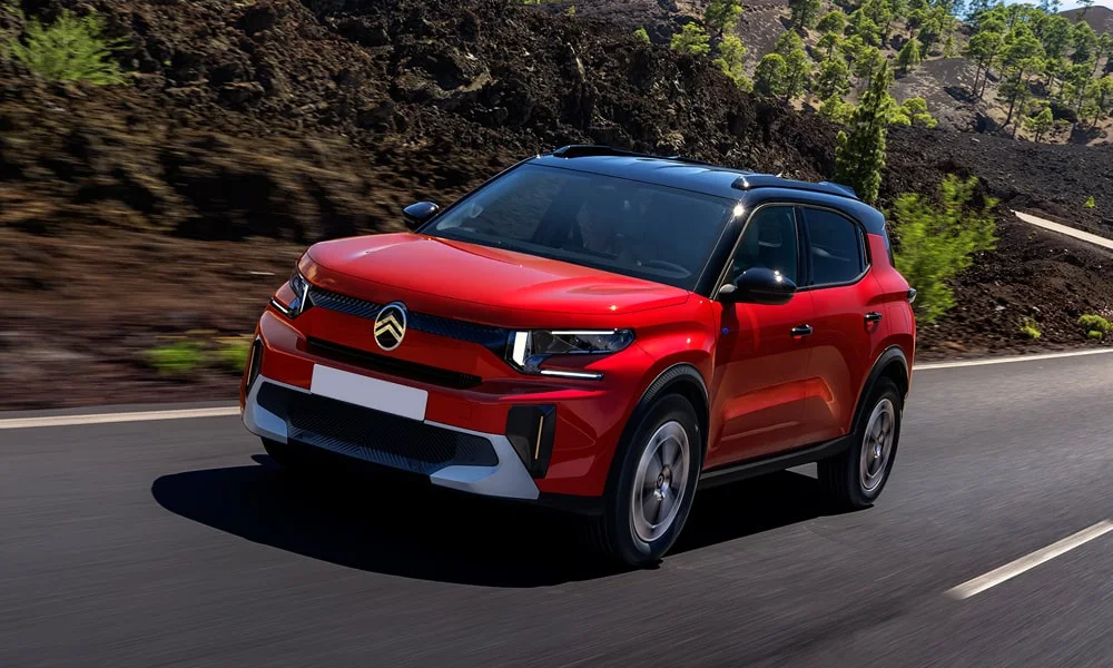 Фото Citroen C3 Aircross (2024) — вид спереди, фото 7. Передок в красном исполнении — крупная светотехника и выразительный бампер. Рисунок ходовых огней — подпись модели, по нему её узнают в потоке Citroen C3 Aircross (2024) — вид спереди, фото 7